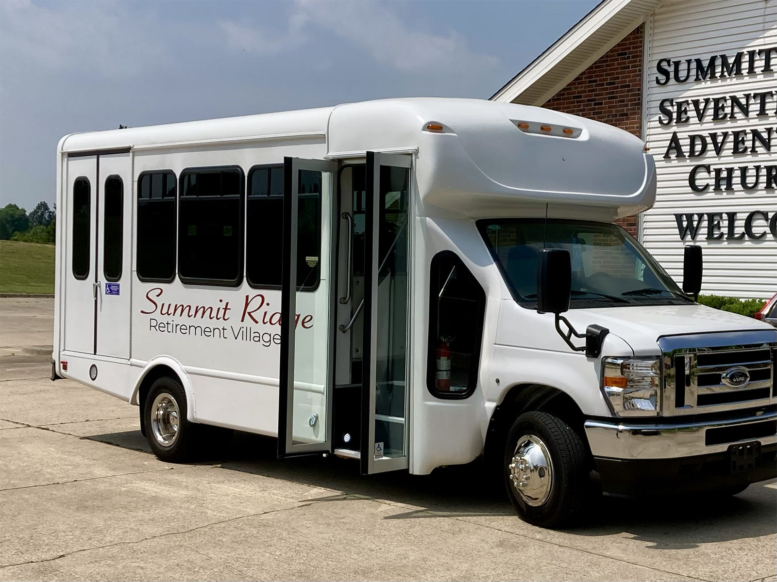 Angled view of the Summit Ridge Retirement Village community shuttle parked in front of Summit Ridge SDA Church