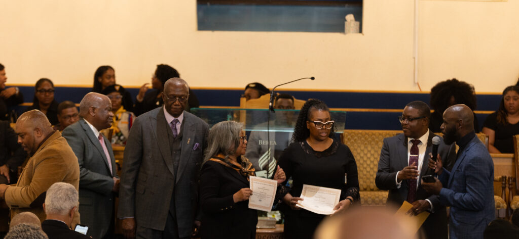A group of people at the front of the church for a special presentation.
