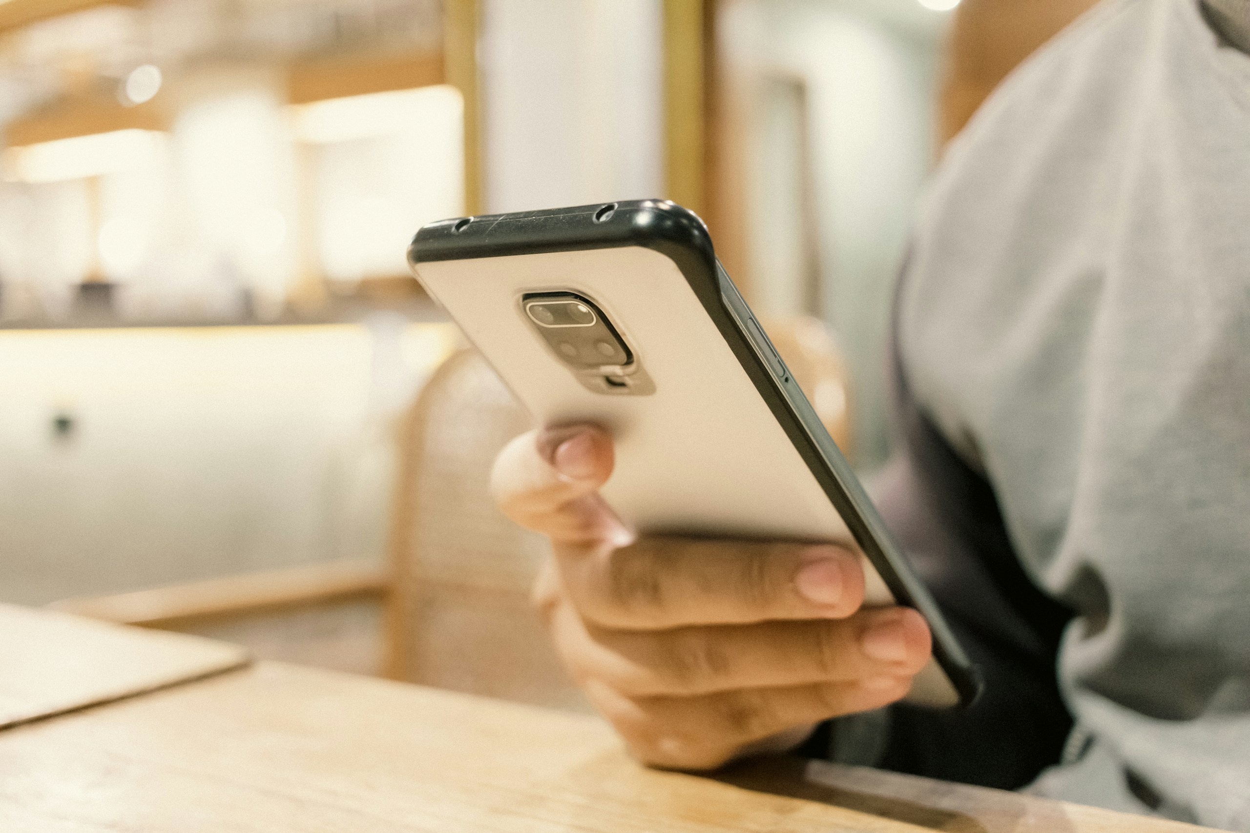 A person sitting at a table with a cell phone