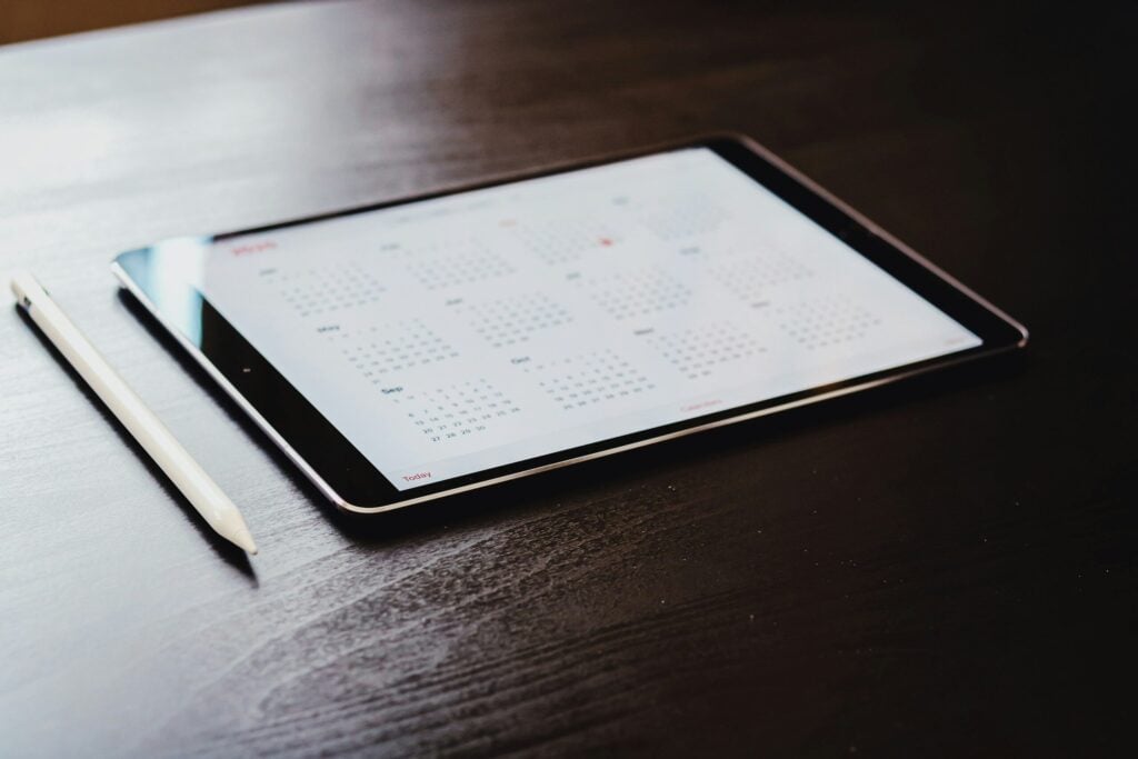 white ipad on brown wooden table
