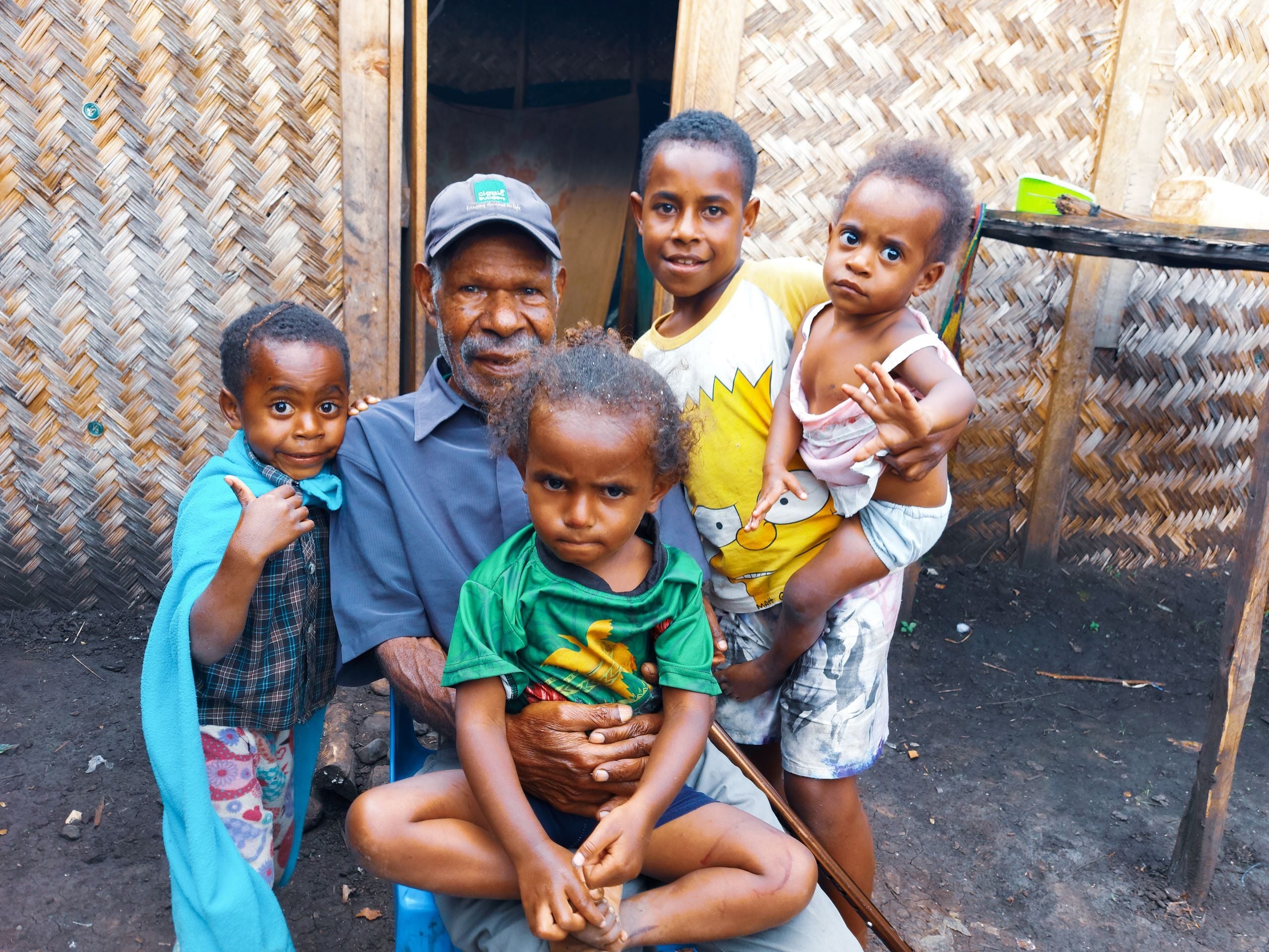 A warm family portrait with a grandfather and children outdoors, showcasing love and togetherness.