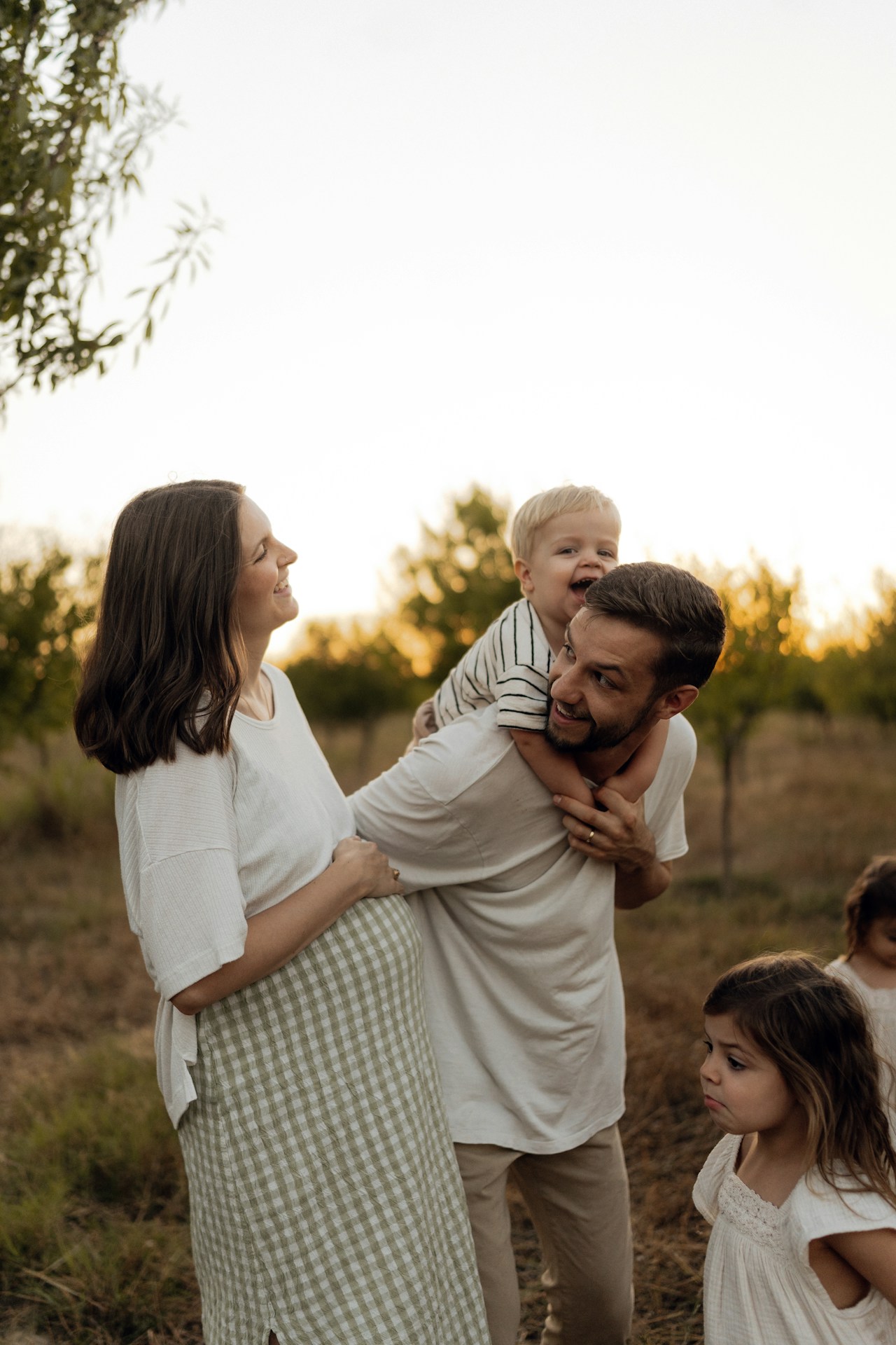 Pregnant mother and father with children outdoors