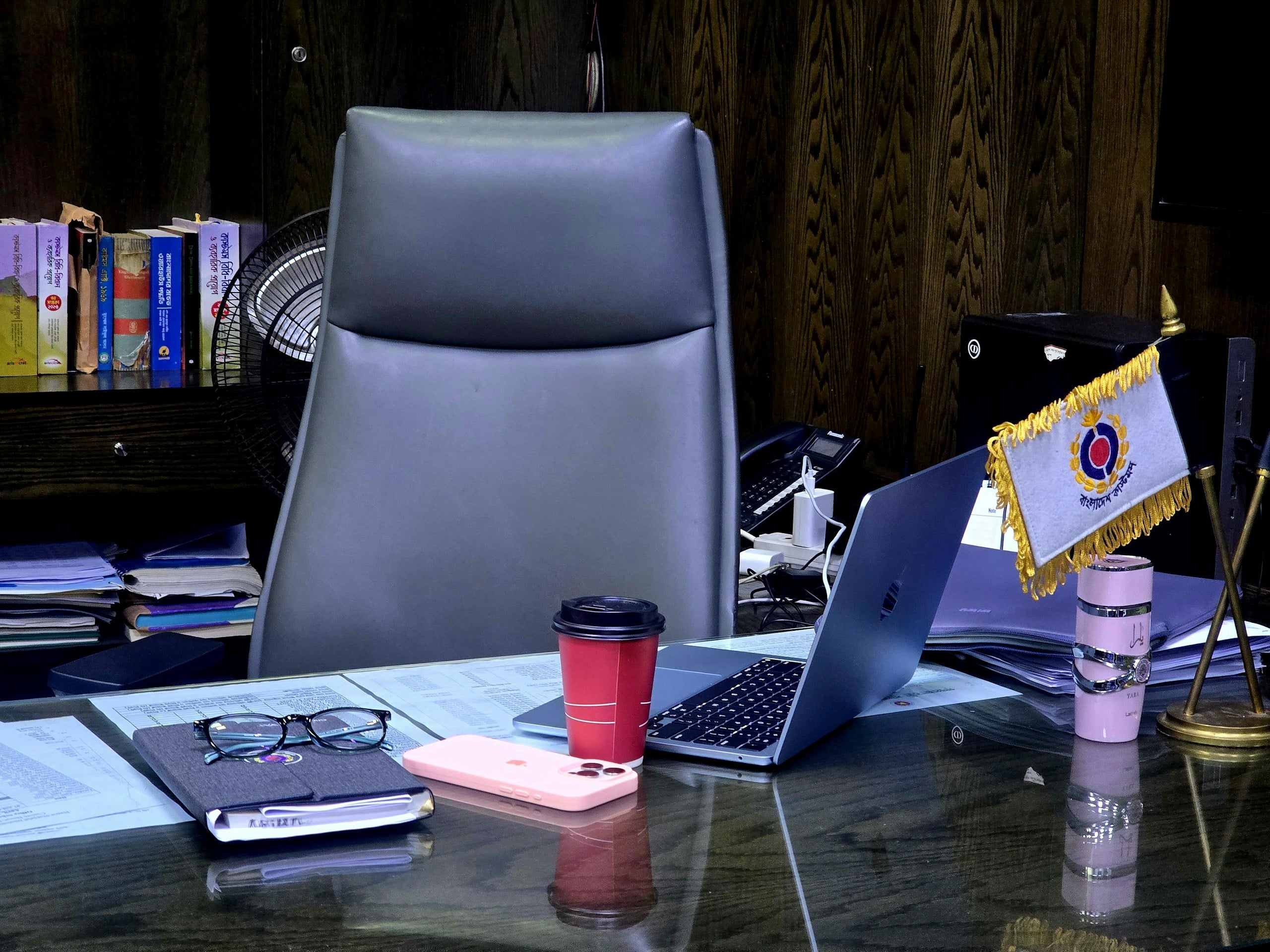 Desk with laptop, coffee cup, and office supplies.