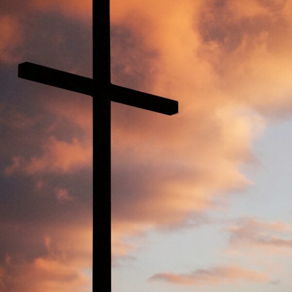 silhouette of large cross under orange sky