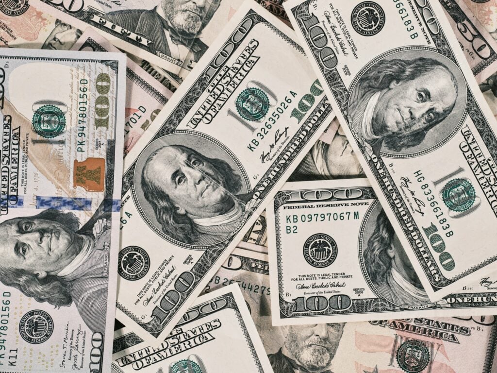 a pile of twenty dollar bills laying on top of each other