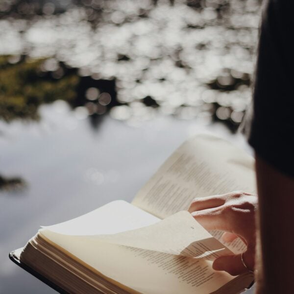 person in black long sleeve shirt holding book