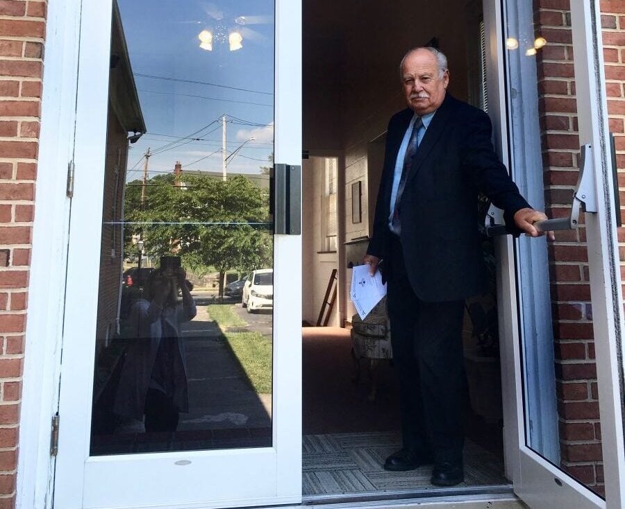 Church member welcoming visitors at the front door
