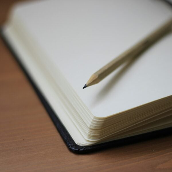shallow focus photography of pencil on book